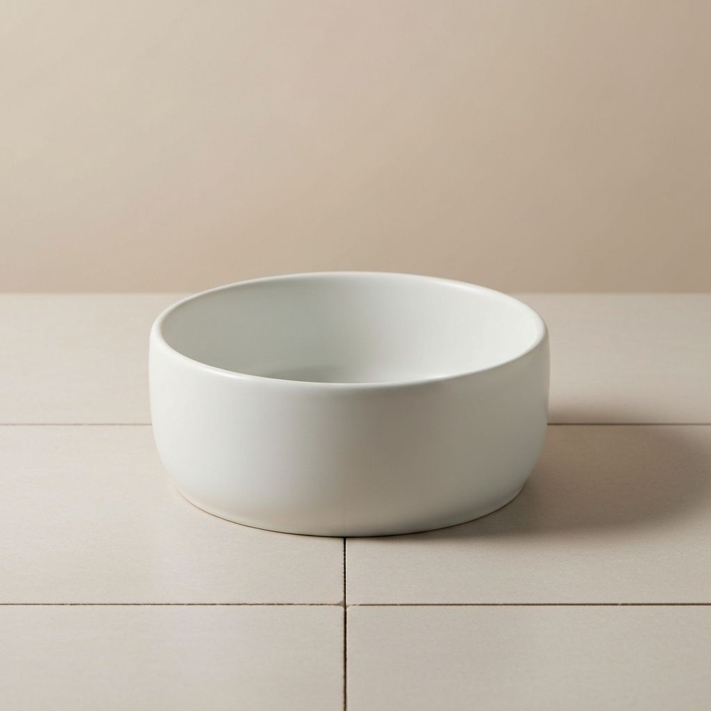 Weiße Keramikschale auf Bodenfliesen, mittlere Größe